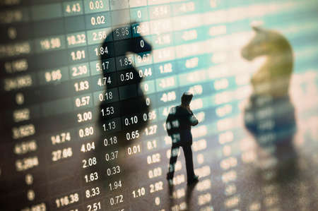 Concept of stock market strategy. Stock market number on screen display with businessman and chess...