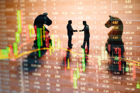 Concept of stock market strategy. Stock market number on screen display with businessman and chess gameの写真素材