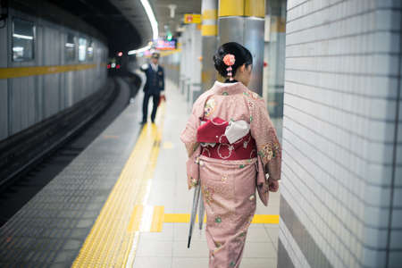 Woman traveller in Kimono dress at subway station in Kyoto.の写真素材