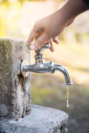 Woman hand shut leaking faucet.の写真素材