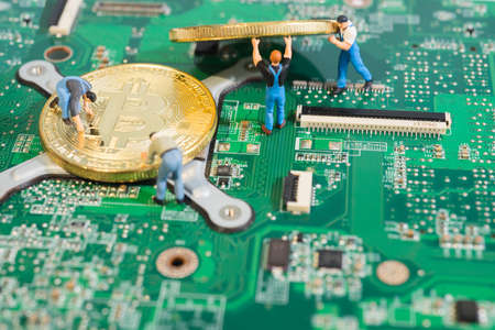 Workers work on computer circuit board moving Bitcoin Cryptocurrency mining concept.のeditorial素材