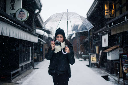 Takayama, Japan - February 12, 2017 : Tourist woman taking picture at Takayama Old Town Street in...