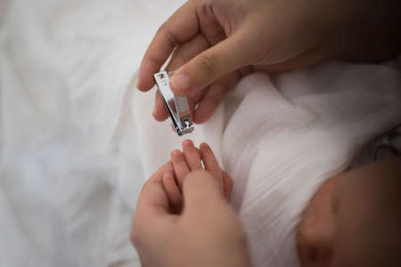 Parrent doing nail cliping for baby toddlerの写真素材
