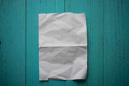 Wrinkle folded paper on grungy wood tableの写真素材