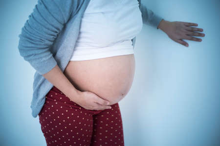 Pregnant woman touching belly and feeling painの写真素材