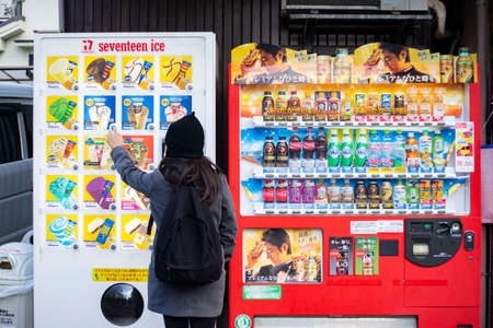 Kyoto, Japan - February 10, 2017 : Woman traveller buying a drink from vending machine.のeditorial素材