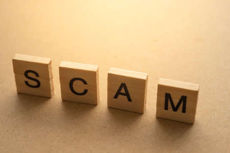SCAM letter on wood plateの写真素材