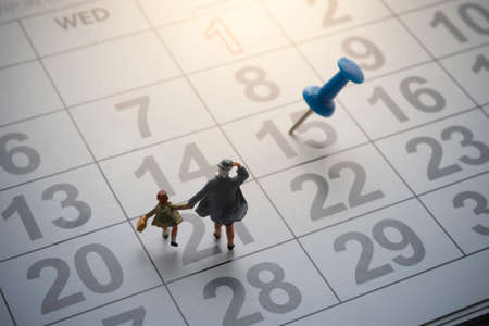 Parent and kid going to school with pinned calendar.の写真素材