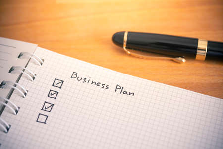 Business plan writing on notebook paperの写真素材