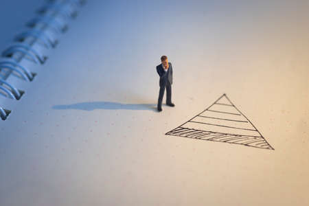 Business decision concept. Businessman thinking with doodle bottom of pyramid chart