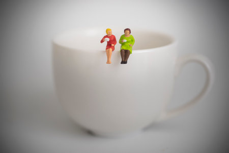 Friends sipping coffee. Two women sipping coffee togetherの写真素材