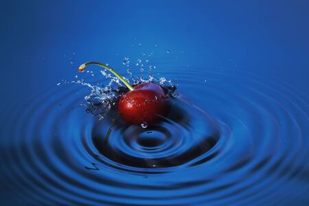 Cherry falls deeply under water with a splash.の写真素材