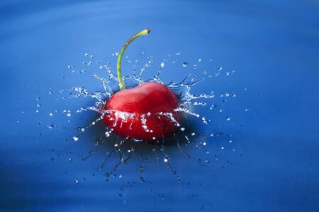 Cherry falls deeply under water with a splash.の写真素材
