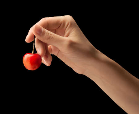 It is red a yellow sweet cherry lies on a hand of the young woman