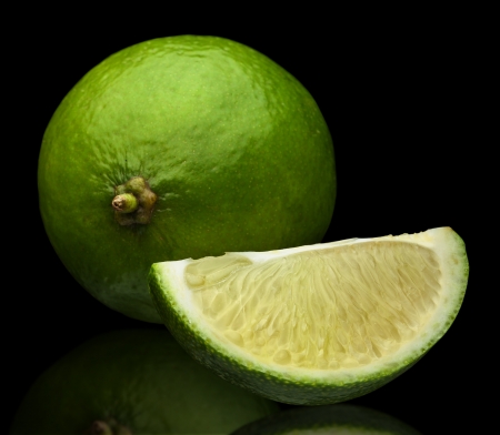 two limes with reflection on a black backgroundの写真素材