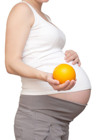 pregnant woman and orange.isolated on a white backgroundの写真素材