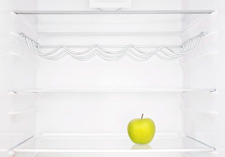 One apple in open empty refrigeratorの写真素材