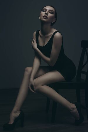 the beautiful girl poses in studio. fashion portrait. make-up. black suit. green toningの写真素材