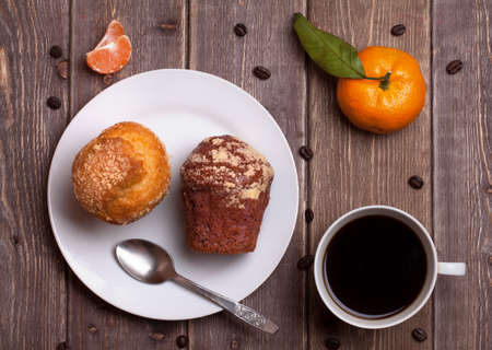 tangerine cake and coffee cup on a wooden table. sweet breakfast.の写真素材