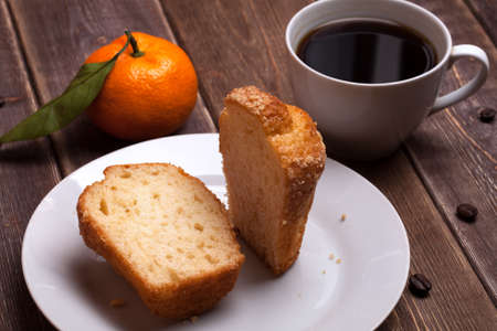 tangerine cake and coffee cup on a wooden table. sweet breakfast.の写真素材