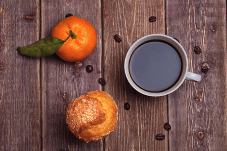 tangerine cake and coffee cup on a wooden table. sweet breakfast.の写真素材