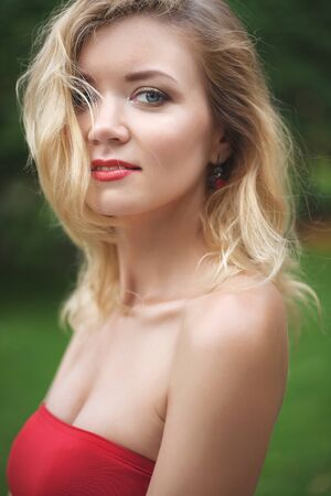 young beautiful girl in a white skirt and a red top. walking in the park and cityの写真素材