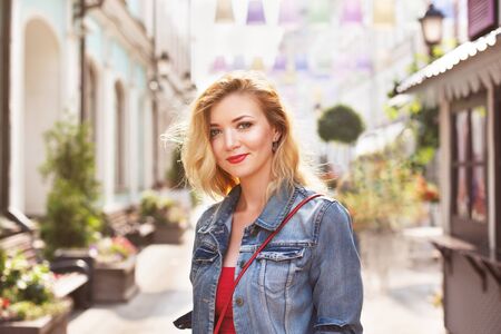 young beautiful girl in a white skirt and a red top. walking in the park and cityの写真素材