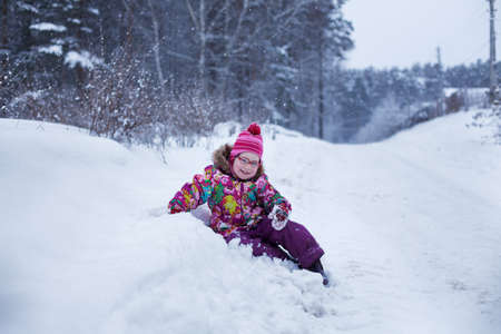 the child fell into the snow, she sits and laughsの写真素材