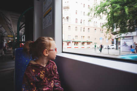 a young girl is riding in a tram and looks with curiosity on the sides
