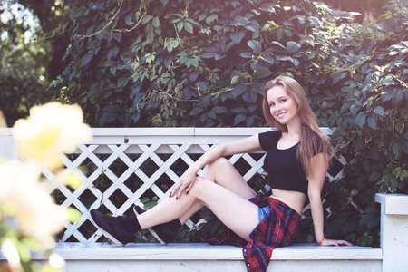 a young girl in shorts and a black topic in the city. bright emotions, style life, sunny dayの写真素材