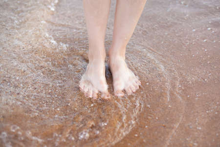 female feet on the sand. rest and sea air.