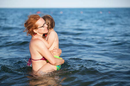 young mother and daughter swims in the sea. childhood and joyの写真素材