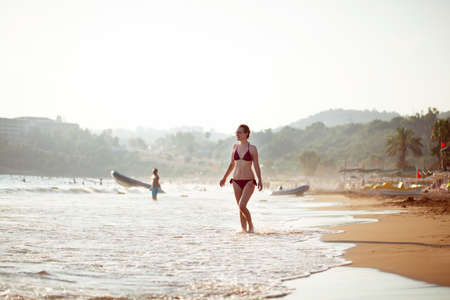 beautiful girl in a swimsuit walks along the beach, the concept of a healthy lifestyle and rest in silenceの写真素材