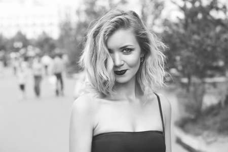 young beautiful girl in a white skirt and a red top. walking in the park and city