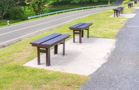 wooden park bench at the road