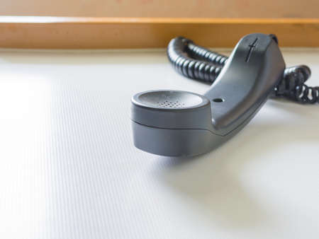 image of telephone with receiver off hook  on table.の写真素材