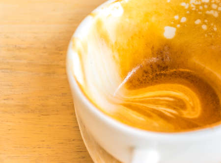 Empty white cup of hot coffee latte on  wooden table.の写真素材