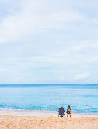 image of  couple sitting on the beach looking on the horizon.の写真素材