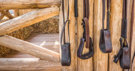 riding horse equipment hang on wooden fenceの写真素材