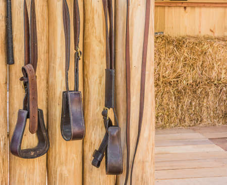 riding horse equipment hang on wooden fenceの写真素材