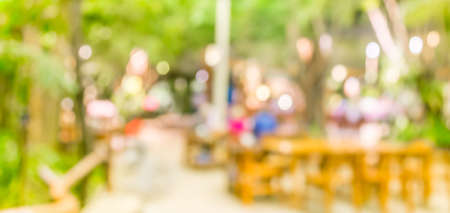 blur image of out door restaurant with green garden in background .の写真素材