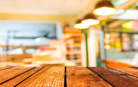 empty brown wooden table and  Coffee shop blur background with bokeh image.