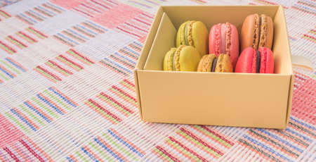 Sweet and colourful french macaroons on cotton cloth background .