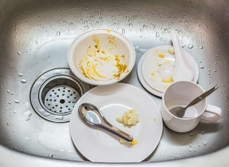 Kitchen conceptual image. Dirty sink with many dirty dishes and kitchenware.の写真素材