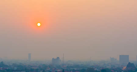 Hazy skyline of Chiang Mai City ,Thailand smog covering buildings with sunrise .の写真素材