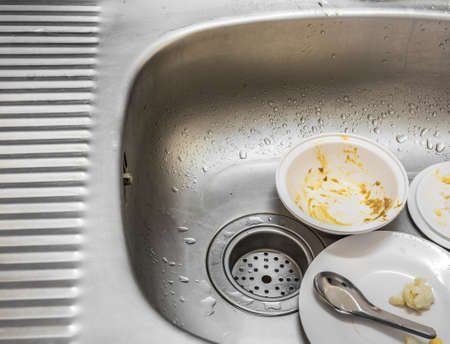 Kitchen conceptual image. Dirty sink with many dirty dishes and kitchenware.の写真素材