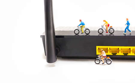 image of mini figure dolls riding bike and running on wifi router  isolated on white background .の写真素材