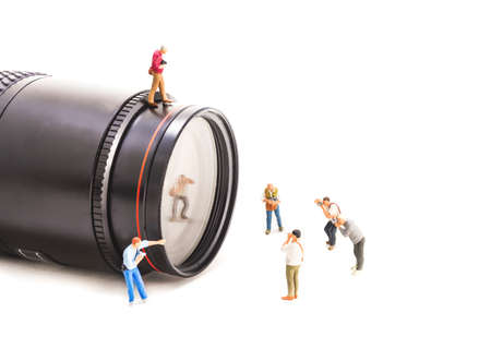 image of mini figure dolls photographer take picture on big DSLR lens isolated on white background.
