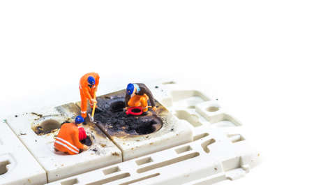 image of mini figure dolls engineer fix Burned plug socket isolated on white background.の写真素材