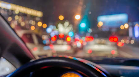 blur image of inside cars with bokeh lights from traffic jam on night time.の写真素材